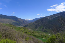 Mirada enrere: al fons veiem nevades les grans muntanyes de la vall Ferrera, entre les que destaca la característica piràmide del Monteixo (2.905m).