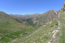 En primer terme, ruïnes de Pigolo des del Carrilet. Al fons, muntanyes del vessant occidental de la Vall Fosca.