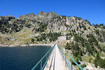 Creuem la presa, al fons el refugi vell de Colomèrs.