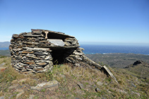 Just al costat de les antenes hi ha una cabana de pedra seca.