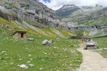 Cabana de pastors, panell explicatiu i, al fons, la capçalera de la vall.