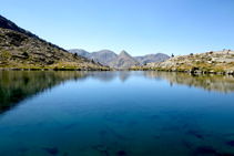 Estany inferior del Pessó, al fons Tossal de la Mina i Tossal des Raspes Roies.
