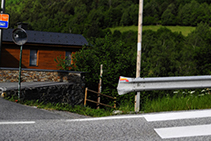 Camí que surt de la carretera i creua el riu Valira del Nord.