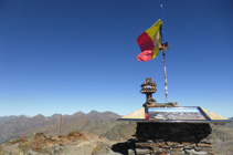 Cim del Comapedrosa amb una taula d´orientació i la bandera andorrana. El massís de la Pica d´Estats al fons.