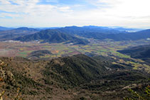 A l´E, les vistes a la Vall d´en Bas amb les serres del Corb i de Finestres.