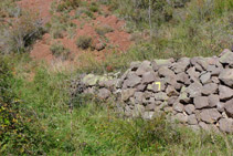 Muret de pedres amb el senyal groc del corriol que hem d´agafar.