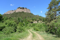 Pista de terra per on avancem i la roca del santuari de la Quar.