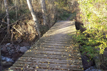 Creuem el riu del Cantó per un pont de fusta.