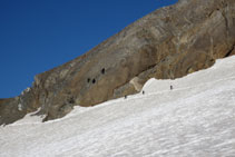 Tres persones dirigint-se a les coves de Russell, a sota el coll de Cerbillona.