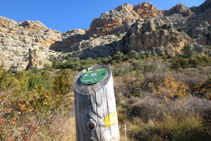 Una estaca de fusta amb un senyal groc ens indica el camí.